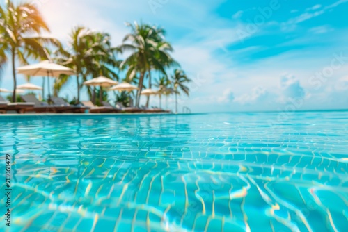 A pool with palm trees in the background and a clear blue sky. The water is calm and inviting