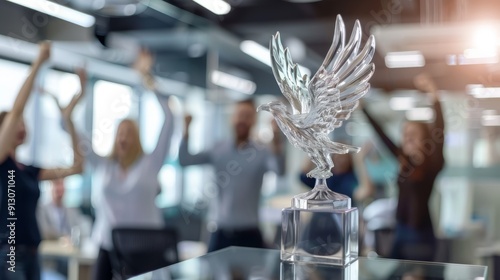 Glass trophy for business success. Celebrate a successful business endeavor with a crystal eagle trophy. This image showcases the award in front of a team of excited colleagues. photo