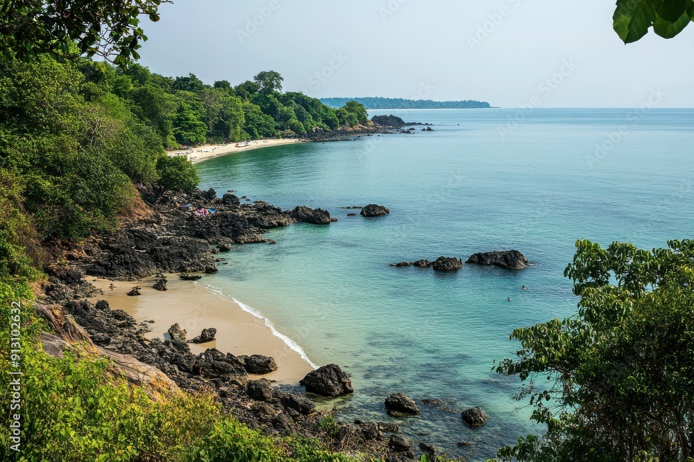 Fototapeta premium view from the top of a rocky beach, the sea is calm and flat with some small waves
