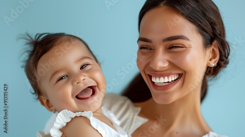 Heartfelt smiles of a mother and her beaming baby, radiating warmth in a bright studio setting.