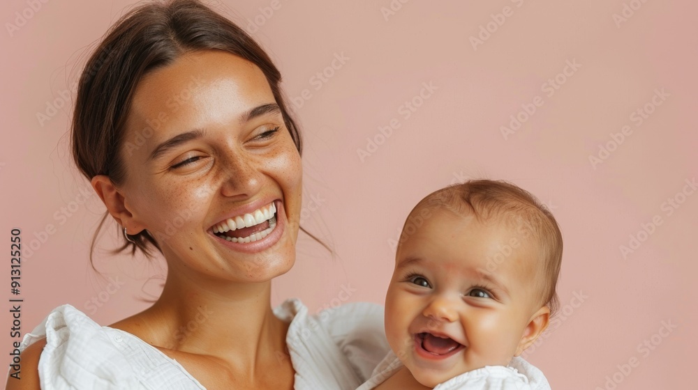 The strong emotional bond between a mother and her beaming baby is elegantly showcased in a bright studio. The strong emotional bond between a mother and her beaming baby is elegantly showcased in a bright studio.