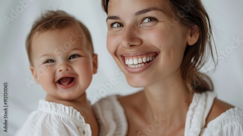 The tender bond between a mother and her happy baby is captured beautifully in a serene studio environment.