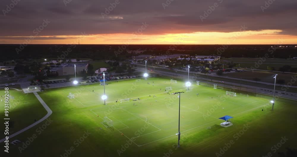 Public sports park with children engaged in football game on grass stadium at night. Active way of life concept Public sports park with children engaged in football game on grass stadium at night. Active way of life concept