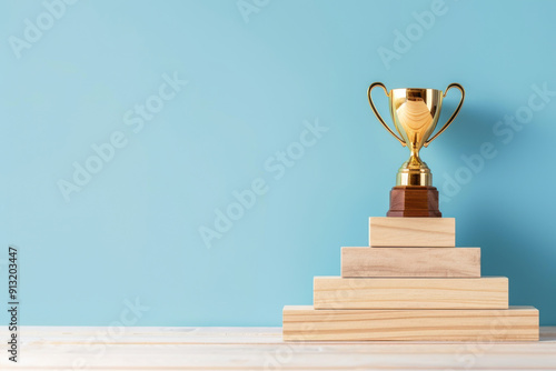 A golden trophy sits atop wooden blocks against a blue background, symbolizing achievement and success.
