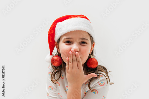 Young girl in Santa hat with Christmas ornaments as earrings photo