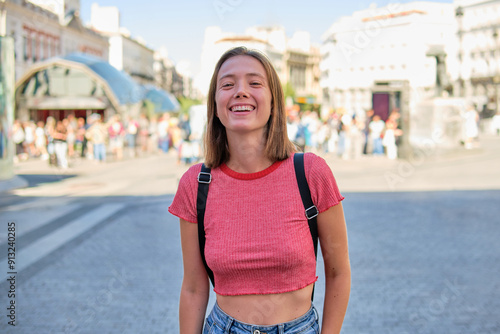 Young woman laughing joyfully in a busy city square