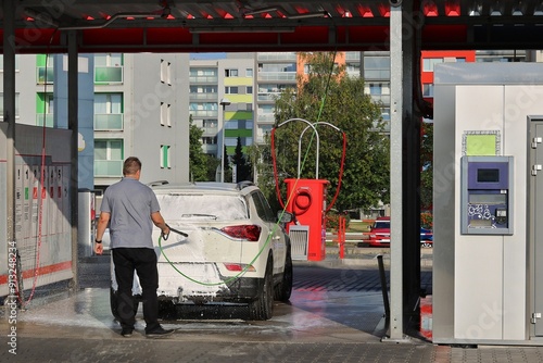 Fotografie Man washes his car in a hand car wash