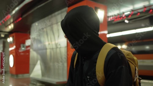 Close-up of suspicious black hooded young man look around, criminal is guarding the victim at subway 4K photo