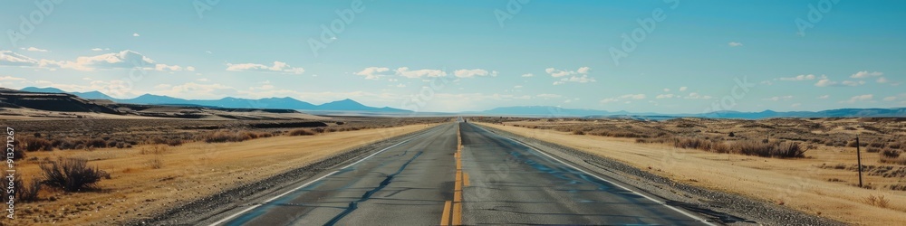 A vast open highway extends through the frame beneath a clear blue sky beckoning boundless opportunities and liberation A vast open highway extends through the frame beneath a clear blue sky beckoning boundless opportunities and liberation