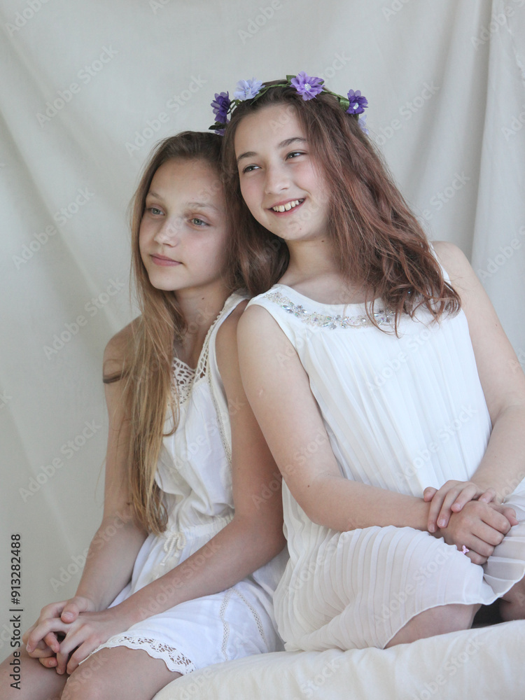 portrait of two cheerful preteen girls in white dresses portrait of two cheerful preteen girls in white dresses