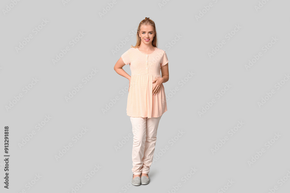 Beautiful young happy pregnant woman on grey background Beautiful young happy pregnant woman on grey background