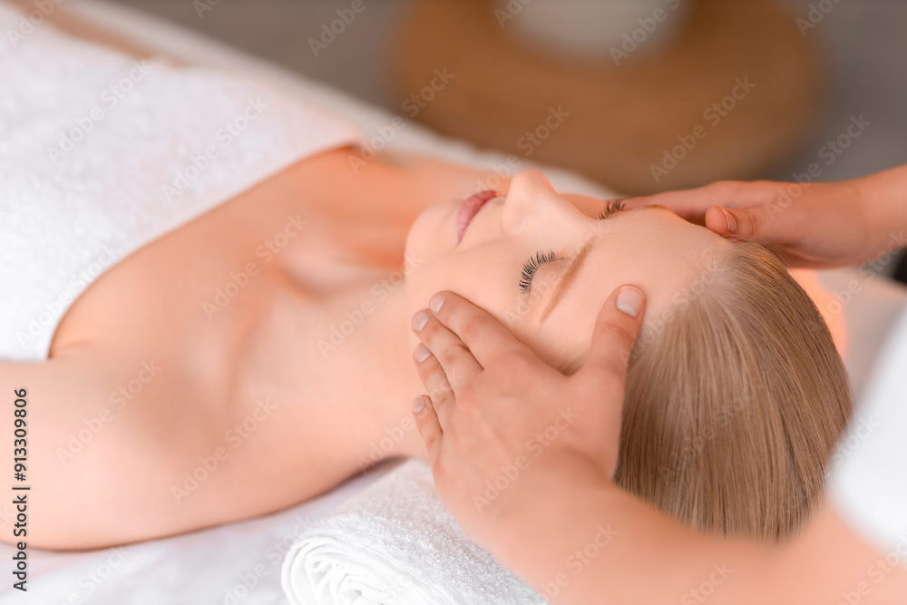 Young woman enjoying relaxing facial massage in spa salon Young woman enjoying relaxing facial massage in spa salon