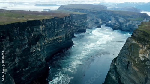 A rocky cliff overlooking the ocean with a few small waves