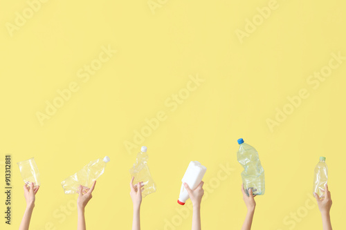 Female hands holding plastic garbage on yellow background. Recycling concept