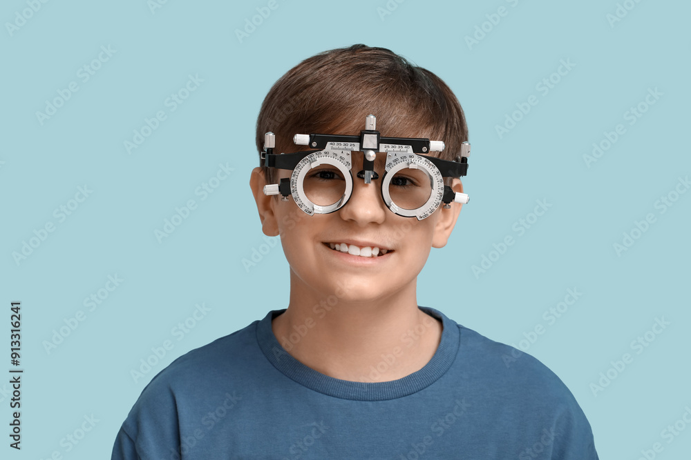 Little boy in optical trial frame on blue background Little boy in optical trial frame on blue background