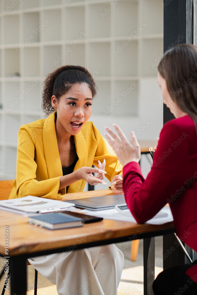 Two professional women engaged in a business meeting, discussing ideas and strategies in a modern office environment. Two professional women engaged in a business meeting, discussing ideas and strategies in a modern office environment.