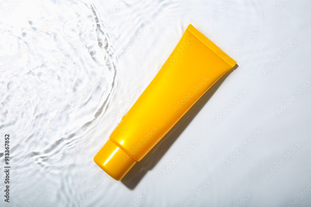 Cosmetic product. Tube with cream in water on light background, top view Cosmetic product. Tube with cream in water on light background, top view