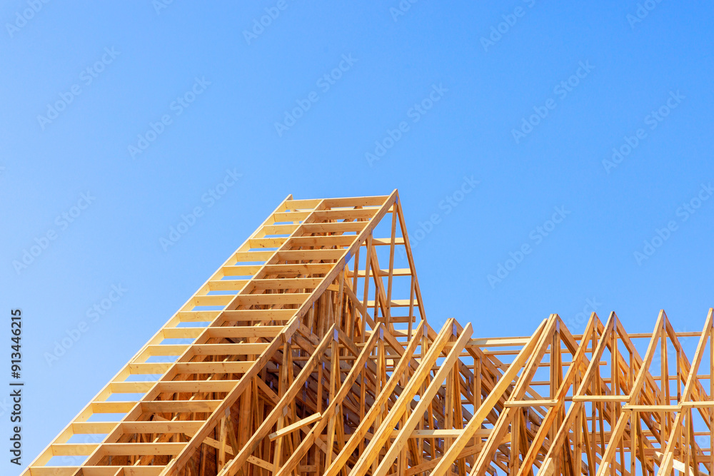 Obraz premium Installation beams of wooden roof trusses to house under construction