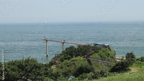 Uljin County, South Korea - July 27th, 2024: A scenic shot of Deunggi Mountain Skywalk extending over the East Sea, offering a breathtaking view of the coastline and Hupo Port. photo