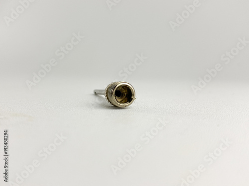 a silver metal needle with a threaded base, designed for inflating objects. Ball pump valve isolated on a white background. Inflate pump valves needle adapter photo