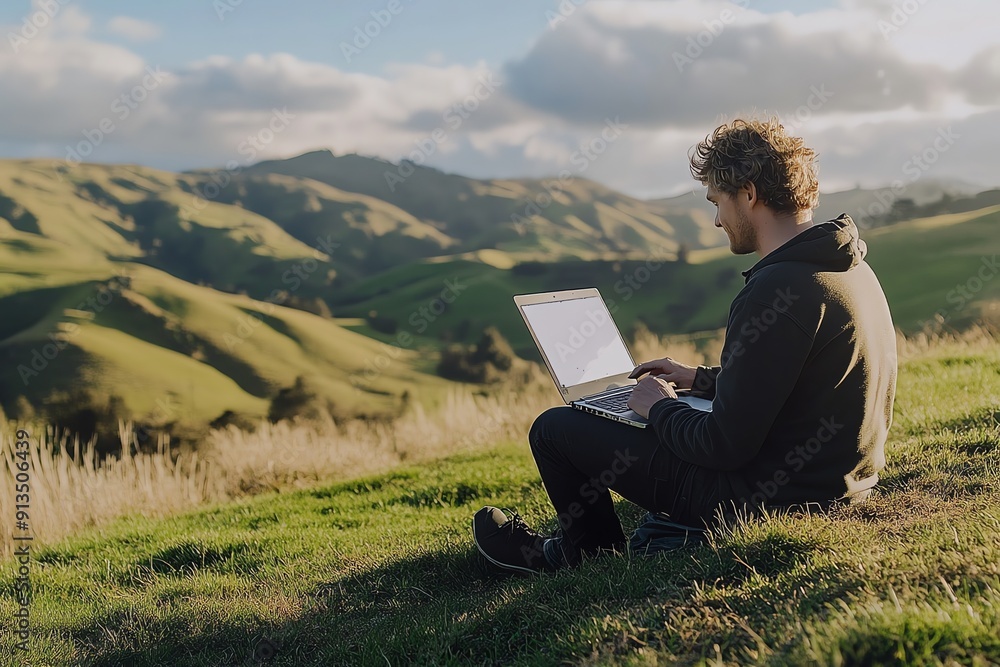 Man Working on Laptop in Rolling Green Hills Man Working on Laptop in Rolling Green Hills