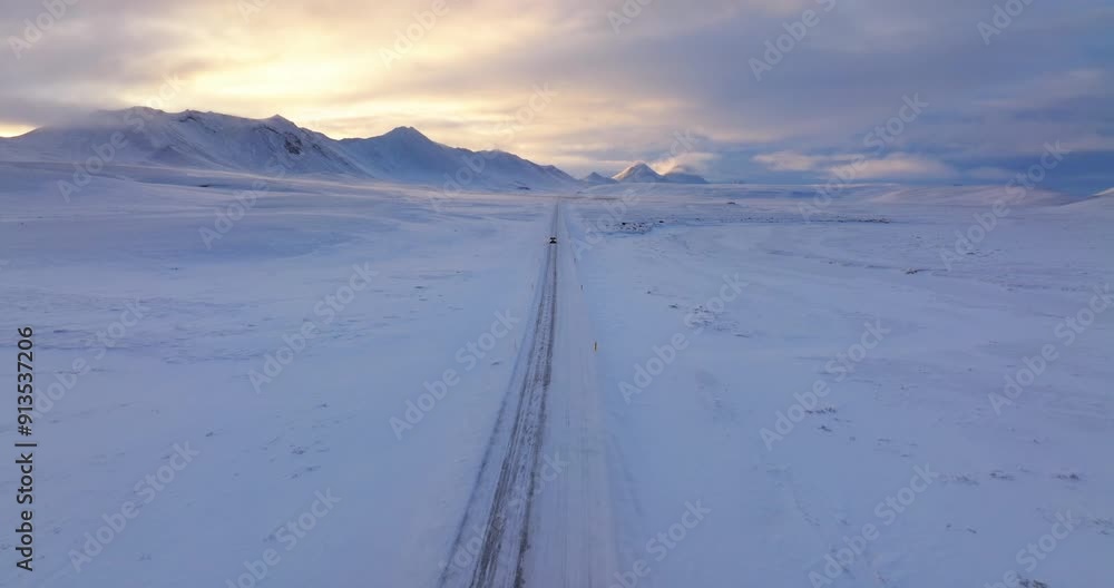 Single Vehicle On Snowy Wilderness Road With Distant Mountains Single Vehicle On Snowy Wilderness Road With Distant Mountains