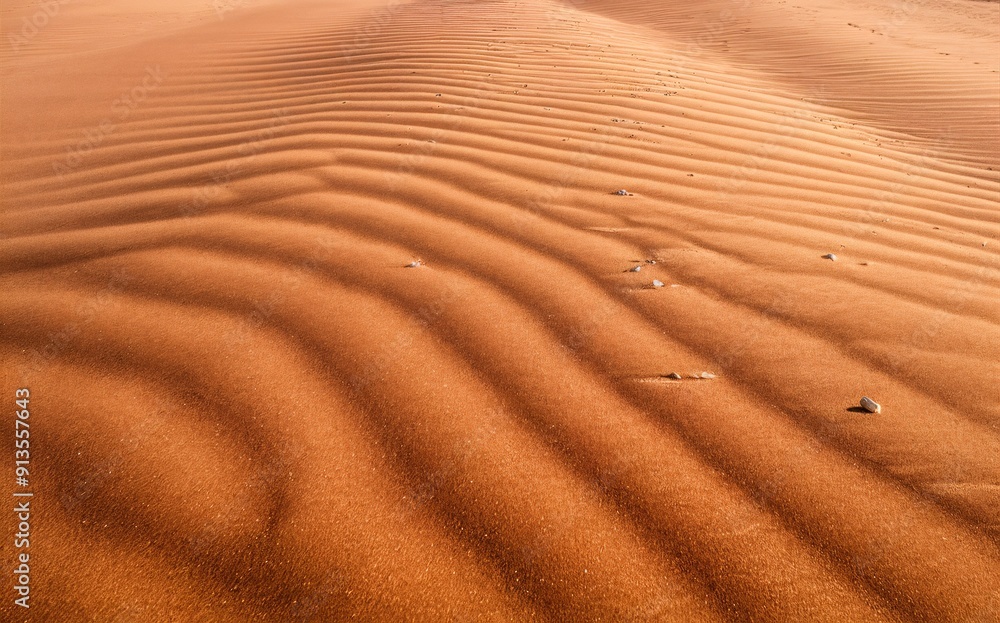 Orange-brown sand dunes with ripples and small rocks, desert-themed background. Orange-brown sand dunes with ripples and small rocks, desert-themed background.