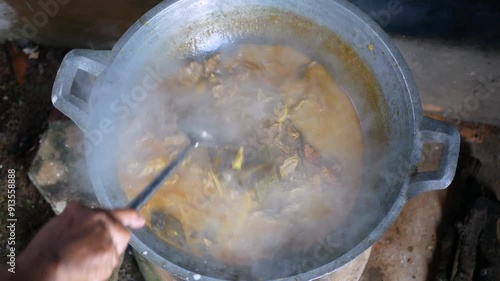 The process of cooking Rendang on a Earthenware furnace or tungku gerabah is Indonesian local stove made from clay, Rendang is a popular traditional indonesian dish photo