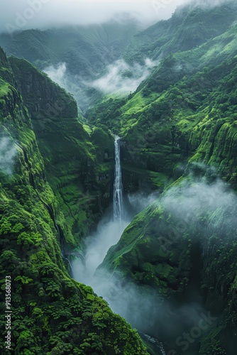 Majestic Waterfall Cascading Through Lush Green Mountains with Misty Clouds in a Serene Natural Landscape