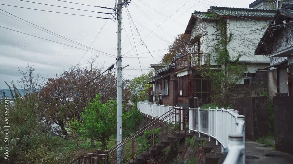 Traditional Japanese houses on a hillside pathway in Saikazaki with overcast sky Traditional Japanese houses on a hillside pathway in Saikazaki with overcast sky