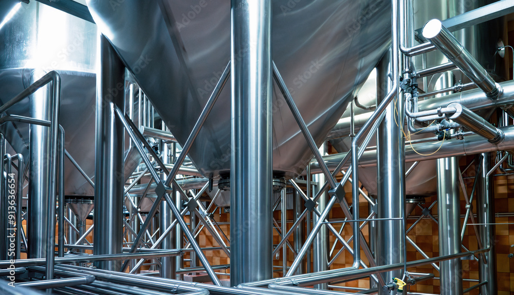 Complex network of gleaming stainless steel pipes at brewery, intricate infrastructure essential for modern beer production. Complex network of gleaming stainless steel pipes at brewery, intricate infrastructure essential for modern beer production.