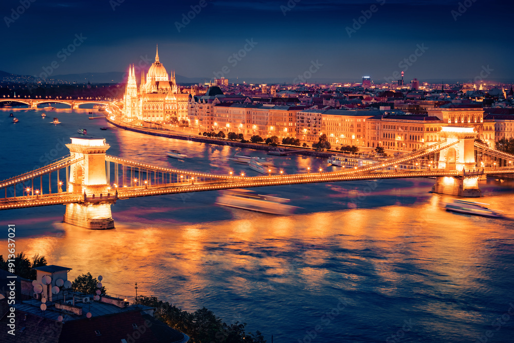 Obraz premium Illuminated summer cityscape of Hungarian parliament building with famous Chain Bridge on the Danube river. Spectacular evening cityscape of Budapest, Hungary, Europe.