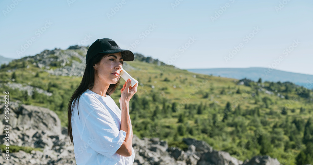 Woman applying sun cream in the summer mountain .Spf stick Woman applying sun cream in the summer mountain .Spf stick
