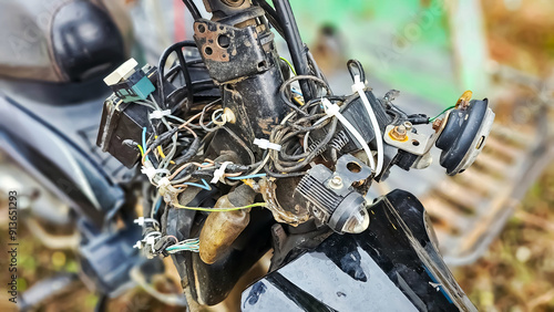 Wire a motorcycle engine to run and start. Front view of the headlights on the steering wheel of a motorcycle, Motorcycle repair. A broken and uninstalled motorcycle engine in a repair shop. photo