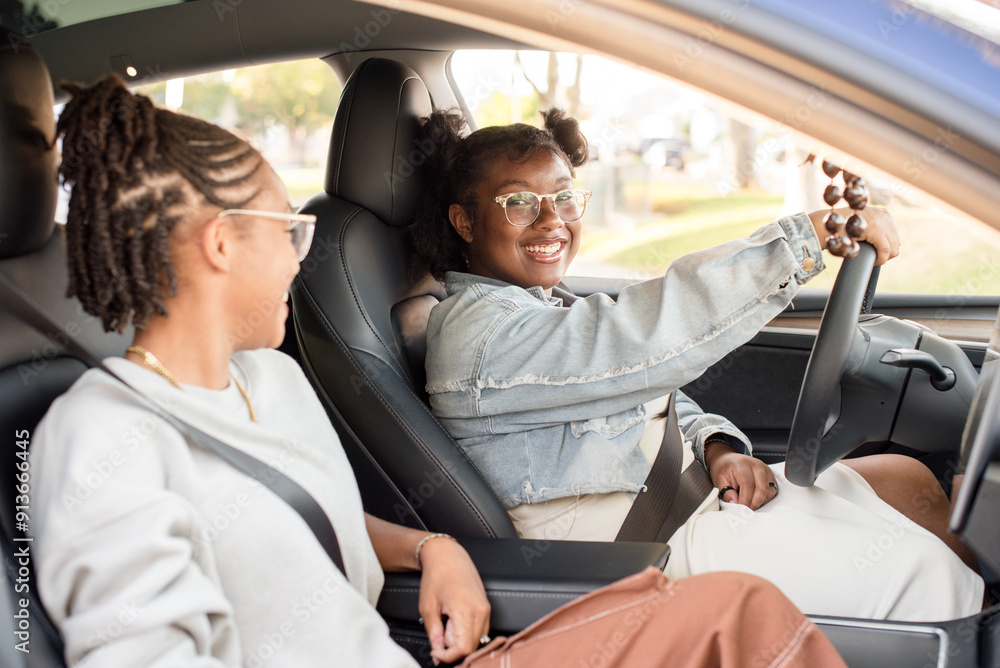 Young girl behind the steering wheel of a car with friend Young girl behind the steering wheel of a car with friend