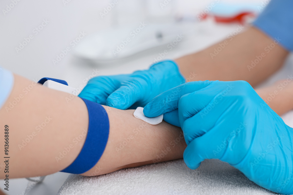 Nurse inserting IV into arm of patient in hospital, closeup Nurse inserting IV into arm of patient in hospital, closeup
