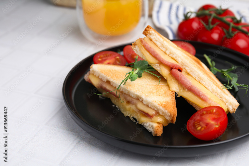 Pieces of toasted bread with melted cheese, ham and tomatoes on white tiled table Pieces of toasted bread with melted cheese, ham and tomatoes on white tiled table
