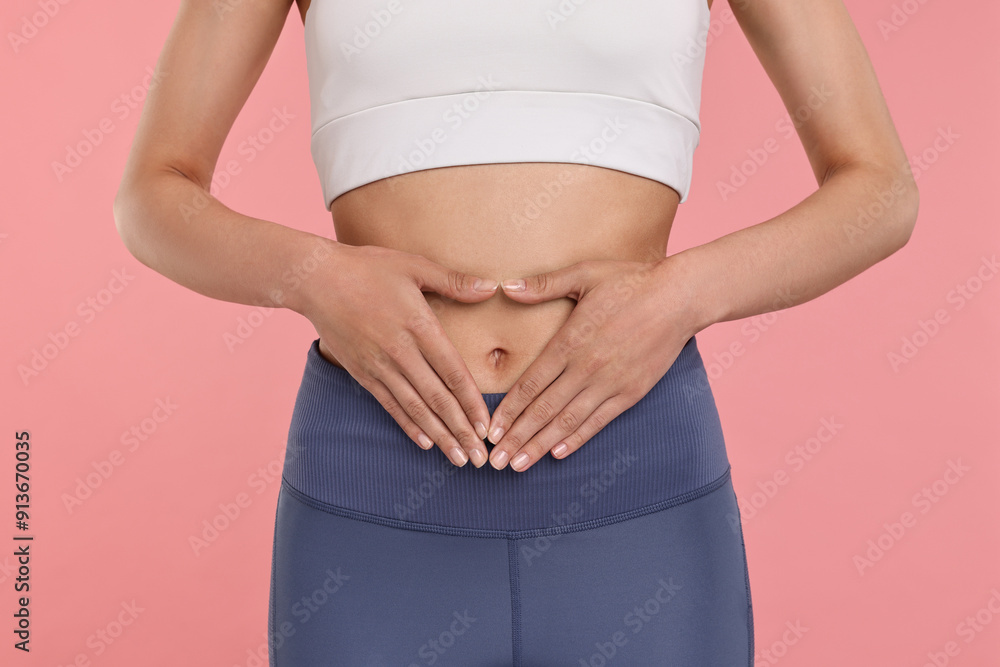 Healthy digestion. Woman making heart shape with hands near her belly on pink background, closeup Healthy digestion. Woman making heart shape with hands near her belly on pink background, closeup