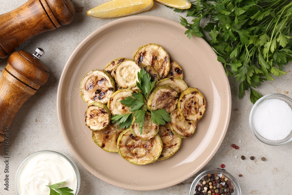Tasty grilled courgette slices served on grey textured table, flat lay Tasty grilled courgette slices served on grey textured table, flat lay