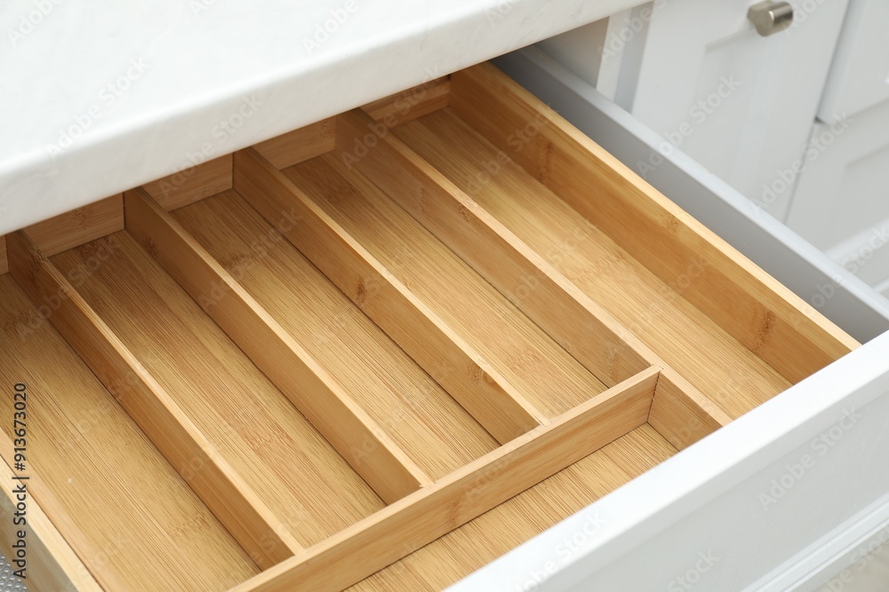 Open drawer of kitchen cabinet with space for cutlery, closeup Open drawer of kitchen cabinet with space for cutlery, closeup