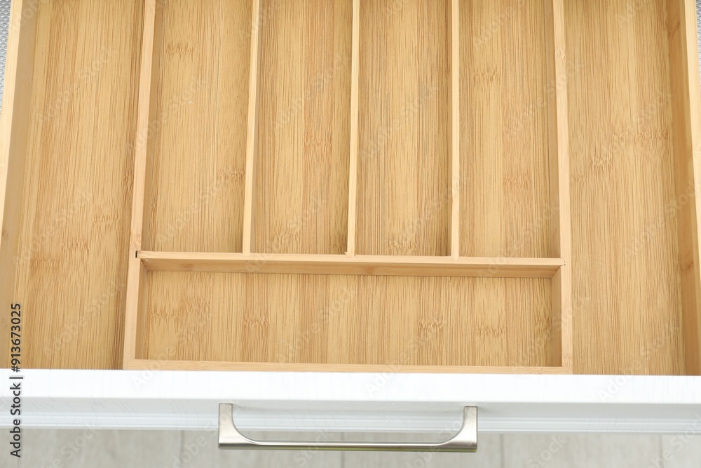Open drawer of kitchen cabinet with space for cutlery, above view Open drawer of kitchen cabinet with space for cutlery, above view