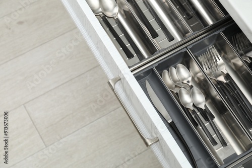 Box with cutlery in drawer, above view. Kitchen utensils storage