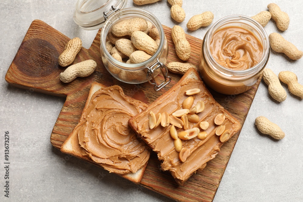 Tasty sandwiches with peanut butter and nuts on grey textured table, flat lay Tasty sandwiches with peanut butter and nuts on grey textured table, flat lay