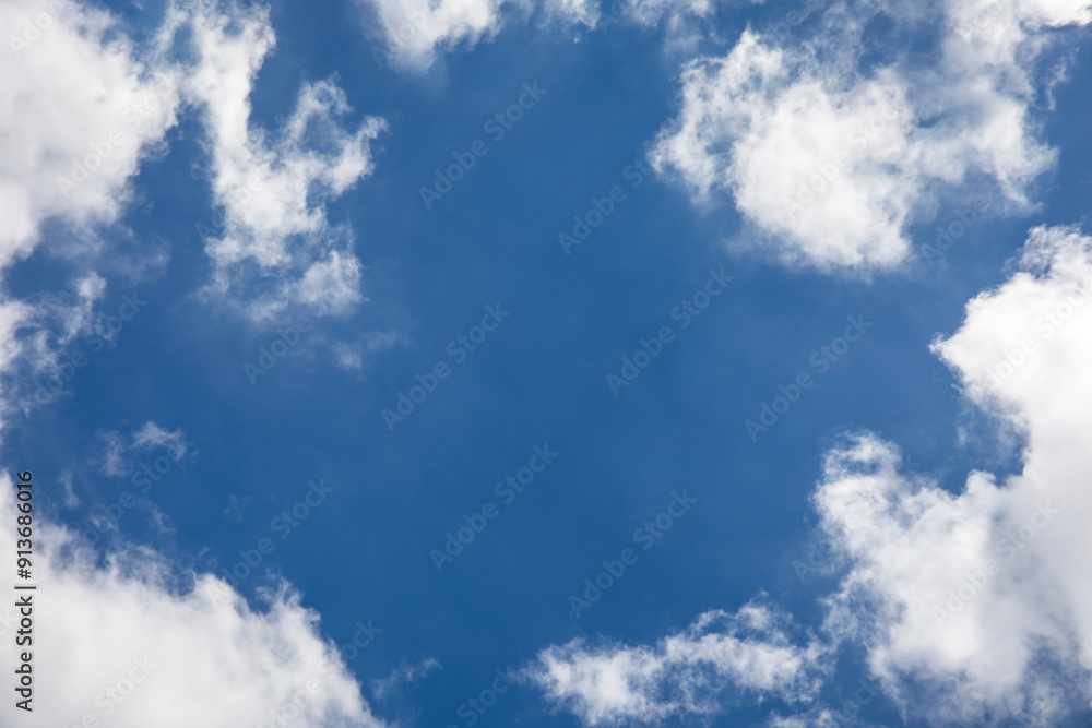 Fototapeta premium Blue sky background and white clouds soft focus, space in the middle, horizontal shape.