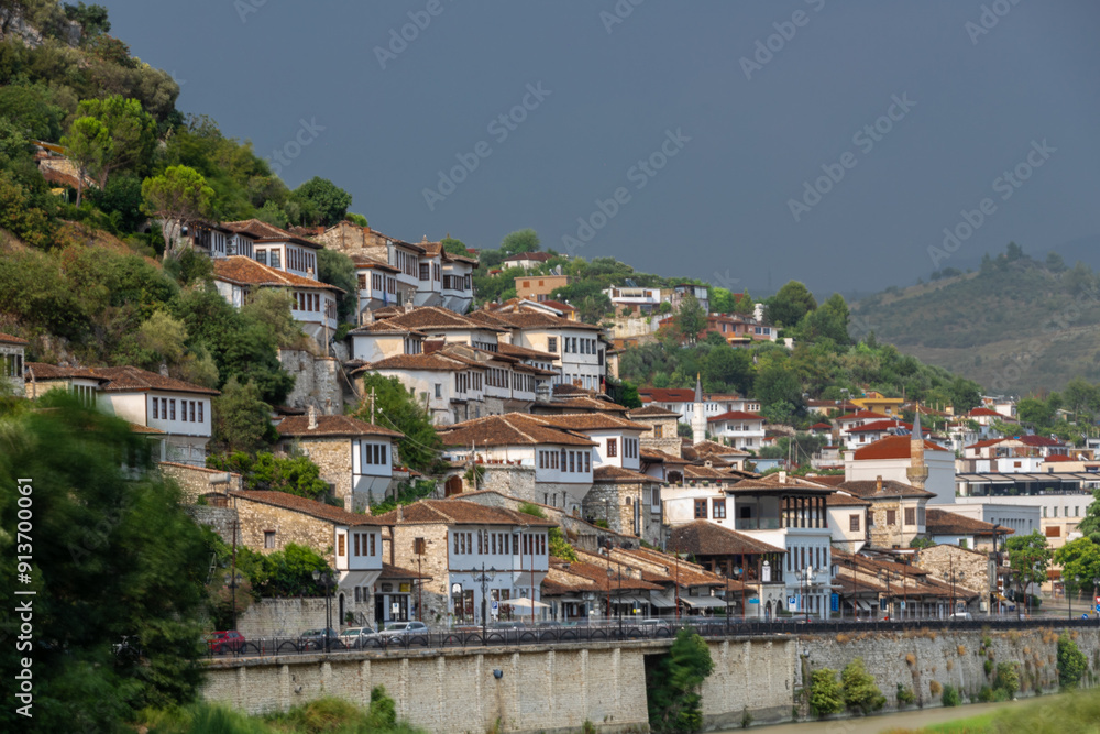 Naklejka premium Sunset over the UNESCO town of Berat on the Osum River in Albania and known for its white Ottoman houses also called the city of One Over One Windows and built against the hill side below the citadel
