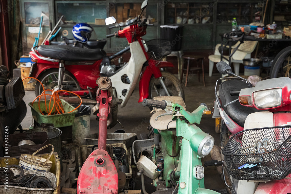 Motorcycle in the Repair shop. Old shop with broken bikes and scooters. Motorcycle repair and services. Motorcycle in the Repair shop. Old shop with broken bikes and scooters. Motorcycle repair and services.