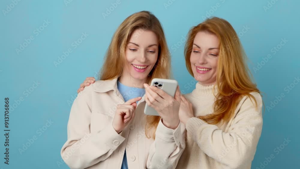 Friends, phone scroll, happiness and swiping on online dating app. Two women sister with Mobile smartphone chat wifi for social media and internet on blue Friends, phone scroll, happiness and swiping on online dating app. Two women sister with Mobile smartphone chat wifi for social media and internet on blue