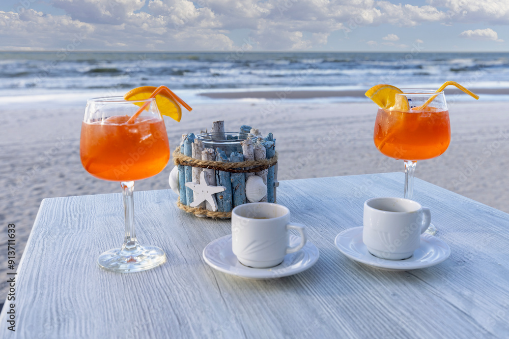 Beach cafe, two cups of coffee and aperol drinks on the table, Baltic Sea, Poland
