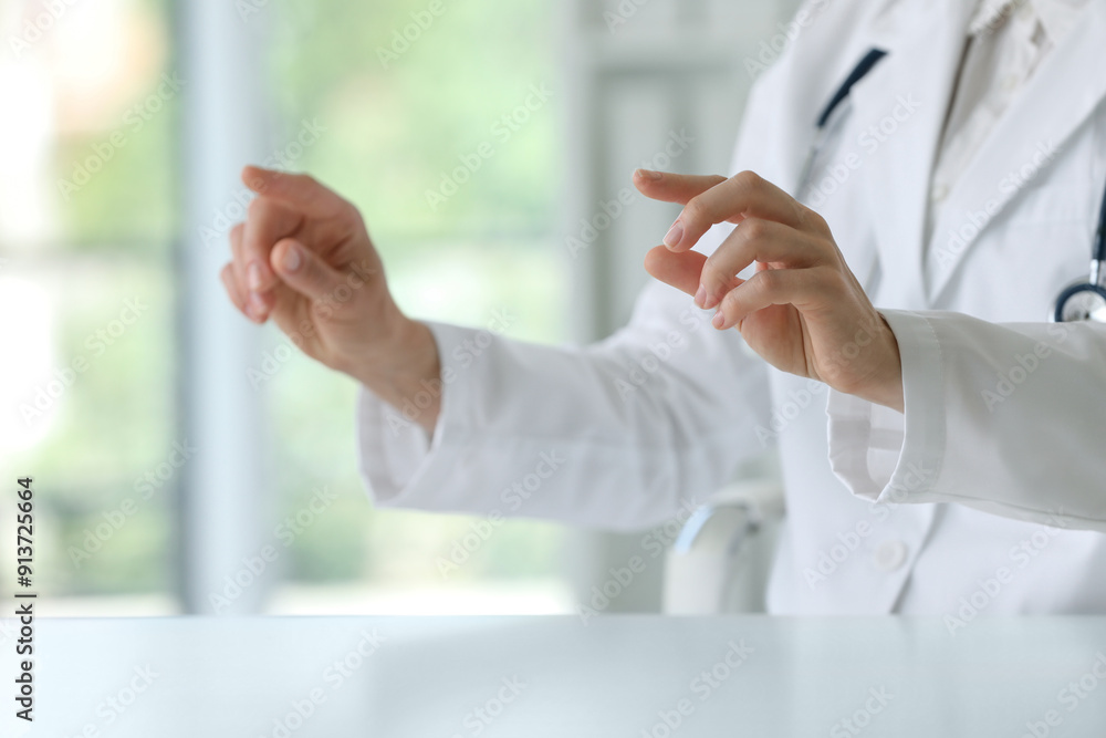 Doctor with stethoscope holding something at table in clinic, closeup