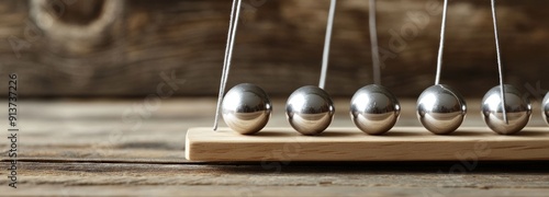 Close-up of Silver Balls Suspended on a Wooden Base photo